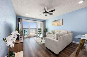 Ein Wohnzimmer mit Sofa, Couchtisch und Deckenventilator.