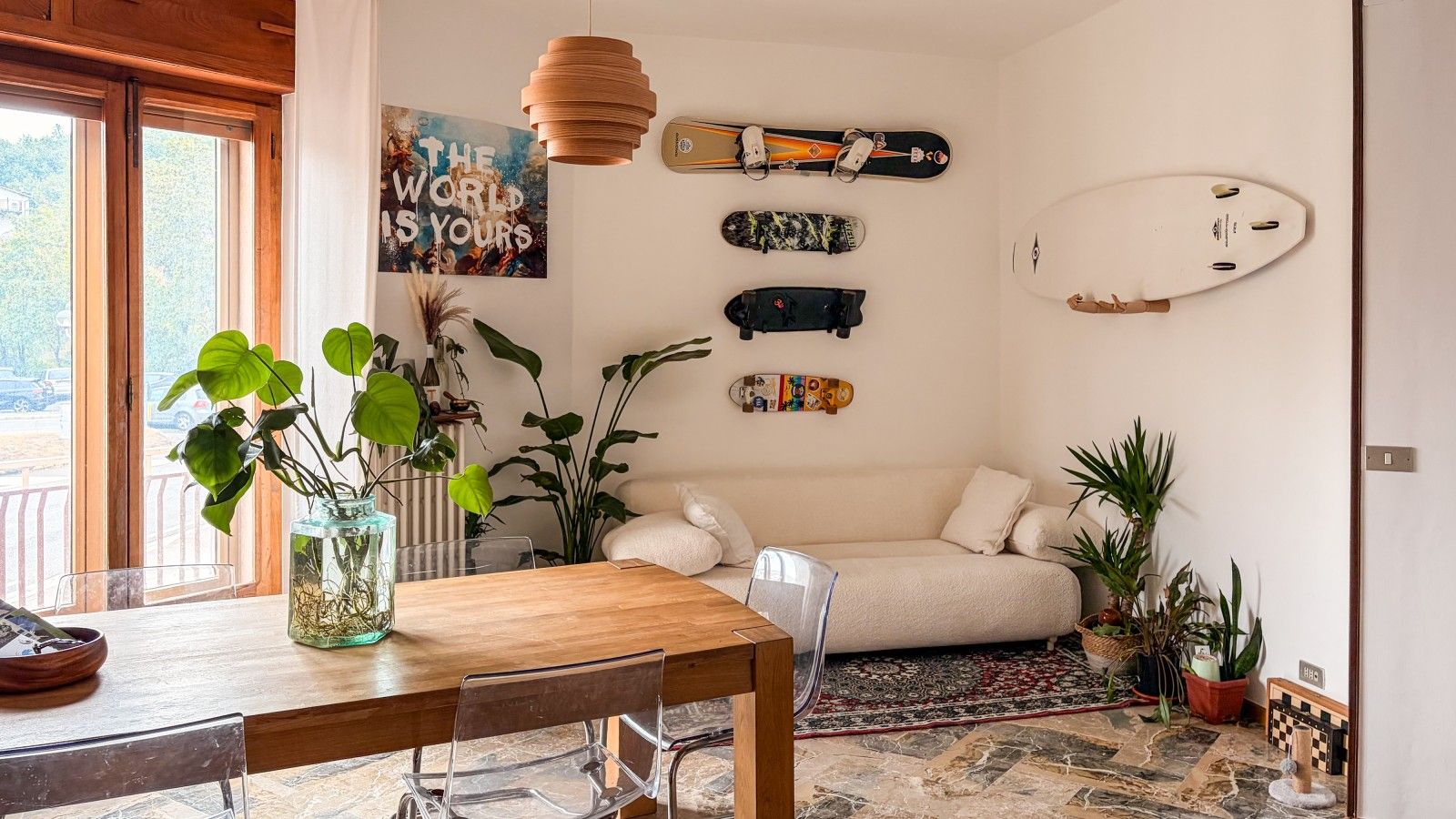 Un salon chaleureux avec une table en bois, un canapé et diverses plantes.