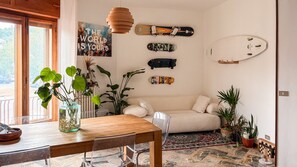 Un saló acollidor amb una taula de fusta, un sofà i diverses plantes.
