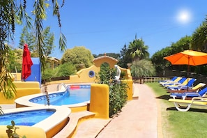 A pool area with multiple swimming pools, lounge chairs, and a red umbrella. - Casa / villa - 6  stanze(con aria condizionata e bagno privato), 4-12 persone (Alvor)