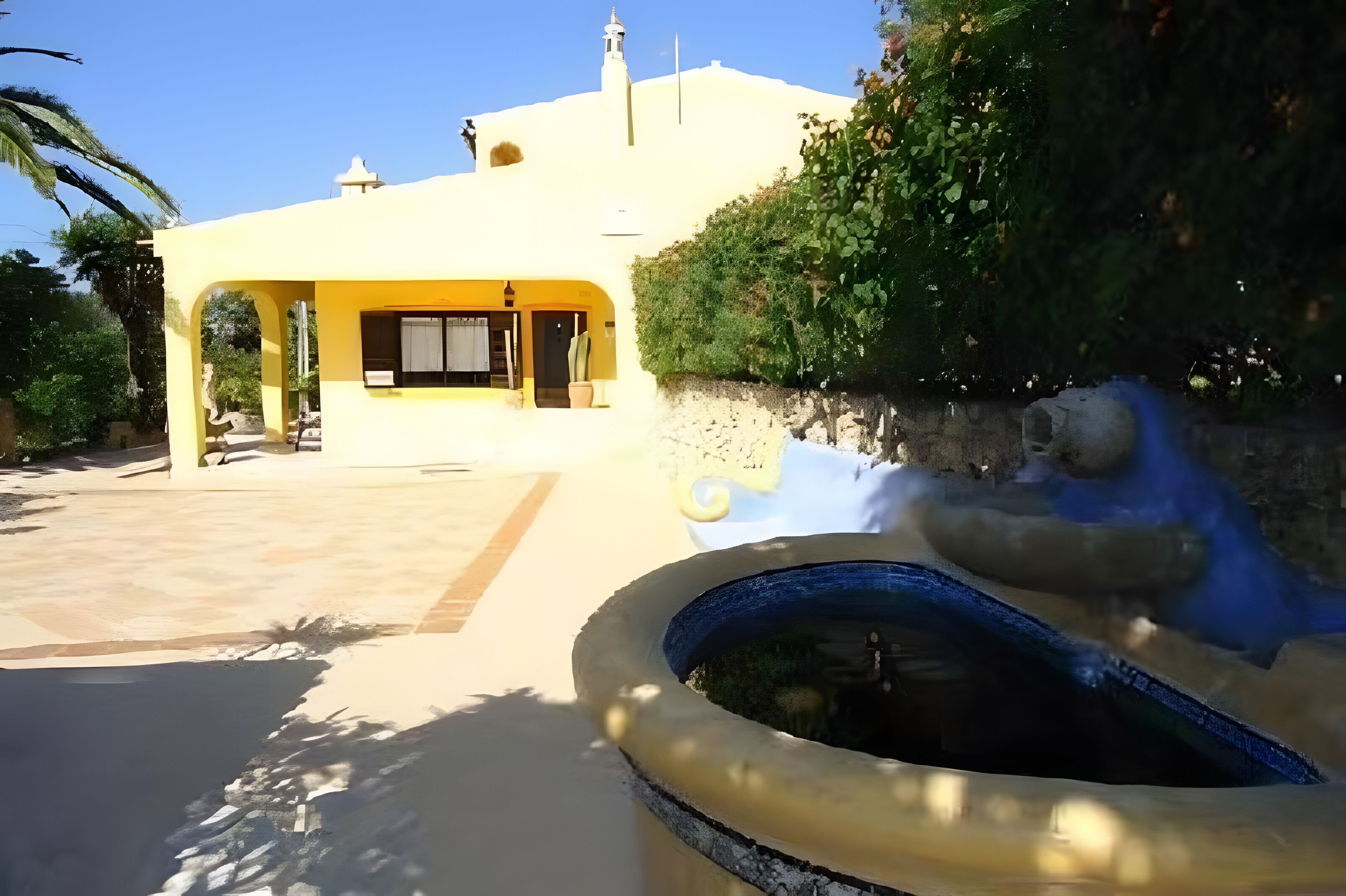 A yellow building with a fountain in the foreground.