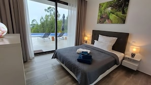 Une chambre d’hôtel comprenant un lit, un bureau, une chaise, une table de chevet, une lampe et une vue sur l’extérieur.