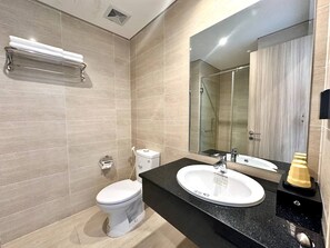 Uma casa de banho moderna com sanita, lavatório e chuveiro.