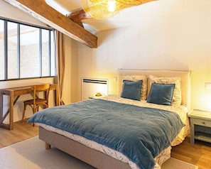 A bedroom with a bed, a desk, and a chair. - Vrbo Property (Sault)
