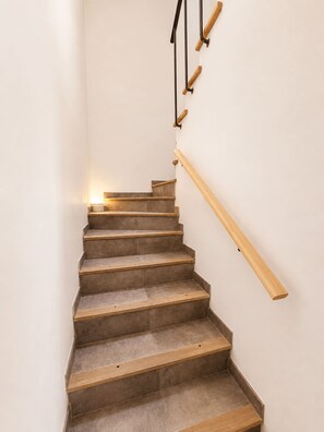 Una escalera con escalones y barandillas de madera que sube.