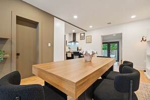 A modern dining area with a wooden table and black chairs. - Our Miami House - Cozy 3BR Near Design District & Wynwood (Miami)