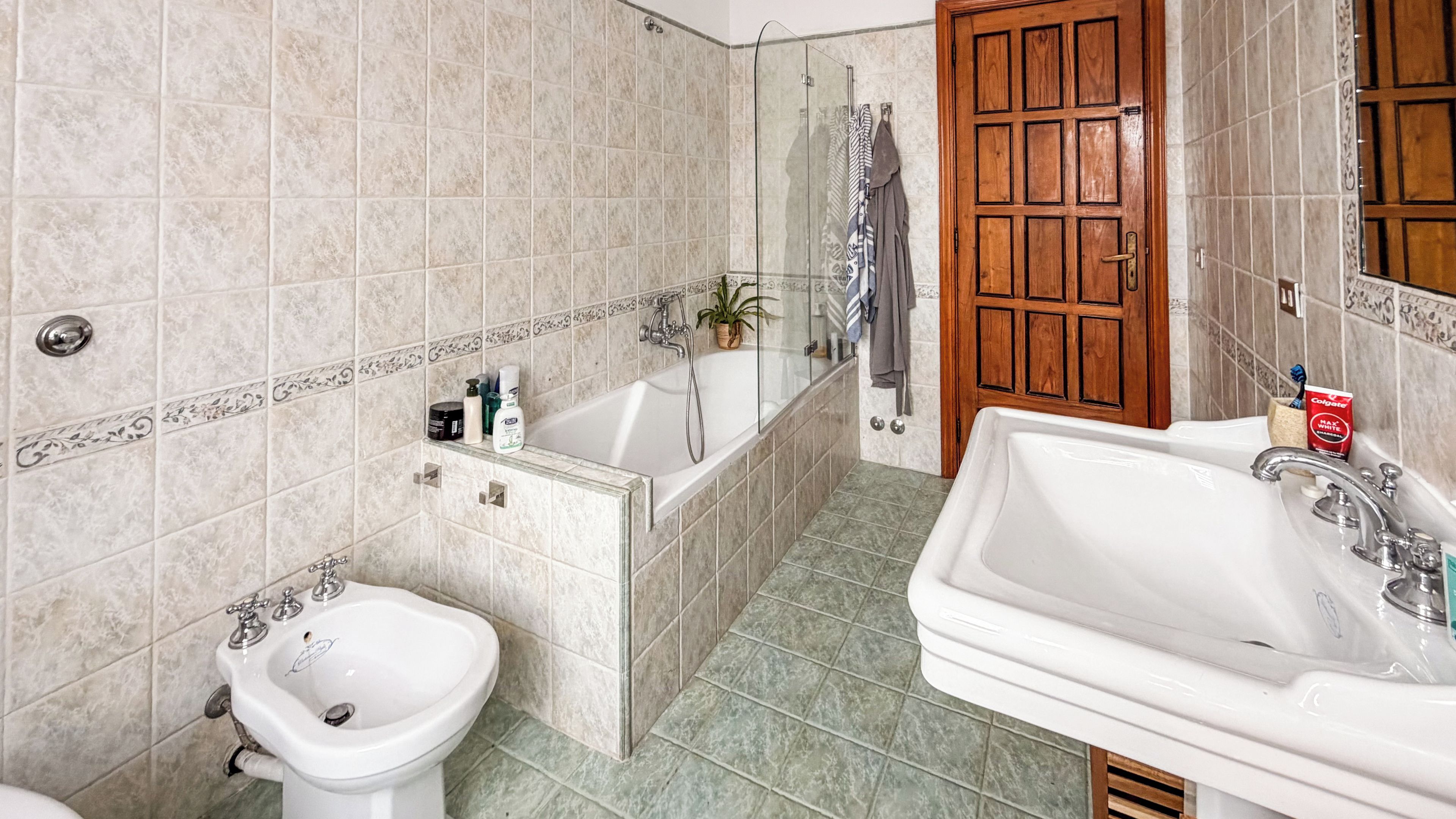A bathroom with a bathtub, a bidet, a sink, and a shower.