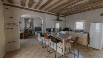 Une cuisine spacieuse avec un îlot central, des tabourets de bar et une grande fenêtre.
