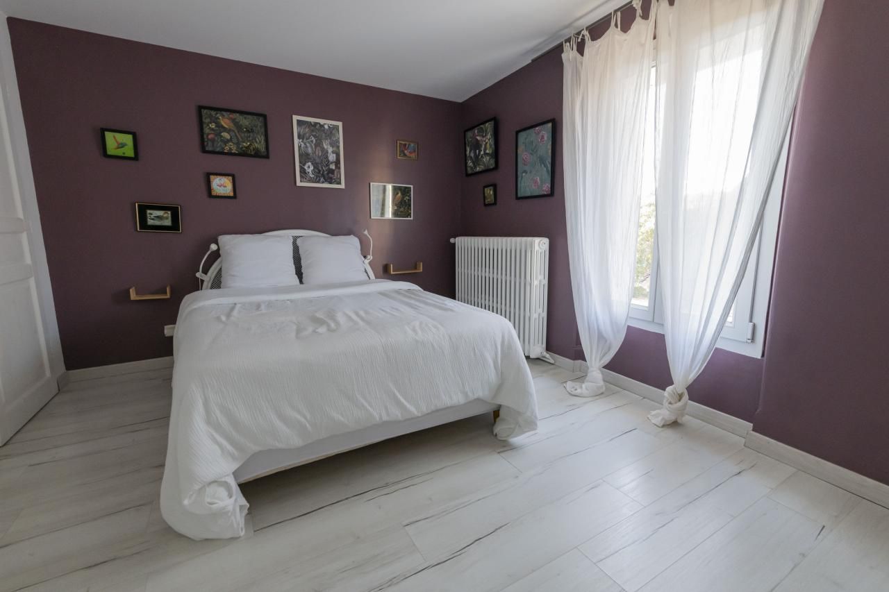 Une chambre à coucher avec un lit, un radiateur et des rideaux.