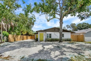 A single-story house with a front yard, a wooden fence, and a tree. - Casa De Campo | Unit A 2Bd 1Bth + Private Entrance (Tampa)