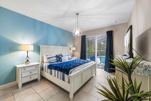A bedroom with a bed, bedside tables, a chandelier, a TV, and a view of the outdoors. - COMING SOON   Solterra 5184 (Davenport)