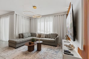 A modern living room with a sectional sofa, a coffee table, and a flat-screen TV mounted on the wall. - NEW   4BR Private Pool  Lazy River   Themed Rooms (Kissimmee)
