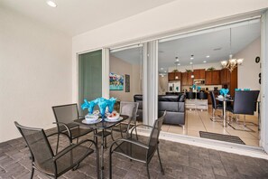 An outdoor patio with a dining table set for four, surrounded by chairs. - NEW   3BR Private Pool  Mickey Room   Air Hockey (Four Corners)