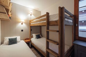A bunk bed room with a wooden ladder, two bedside tables, and wall-mounted lamps. - Creux de l'Ours (Les Allues)