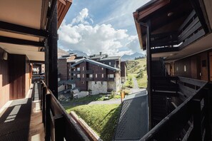 Un hôtel offrant une vue sur un paysage montagneux, avec une façade en pierre et des balcons en bois.