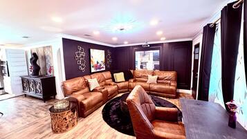A living room with a sectional sofa, a coffee table, and a fireplace.