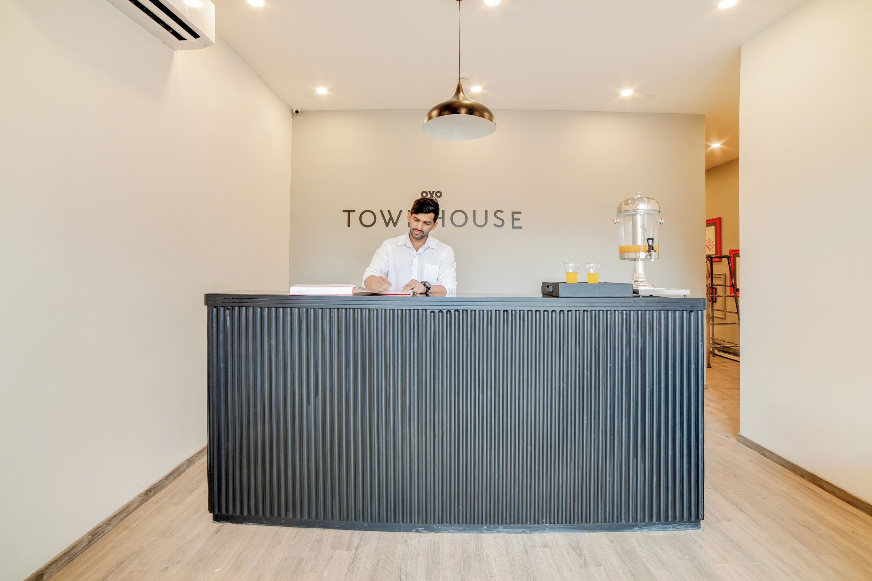 Un mostrador de recepción con un letrero que dice 'TOW HOUSE' y una cafetera.