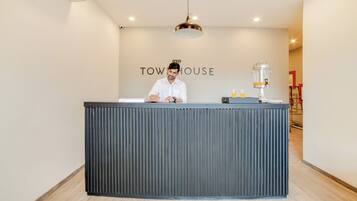 Un mostrador de recepción con un letrero que dice 'TOW HOUSE' y una cafetera.