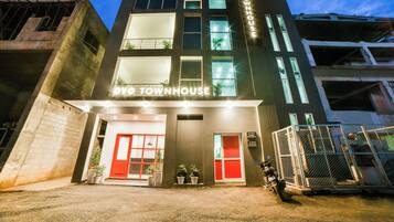 Un edificio de varios pisos con un letrero que dice 'OYO TOWNHOUSE'.