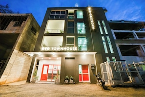 Un edificio de varios pisos con un letrero que dice 'OYO TOWNHOUSE'.