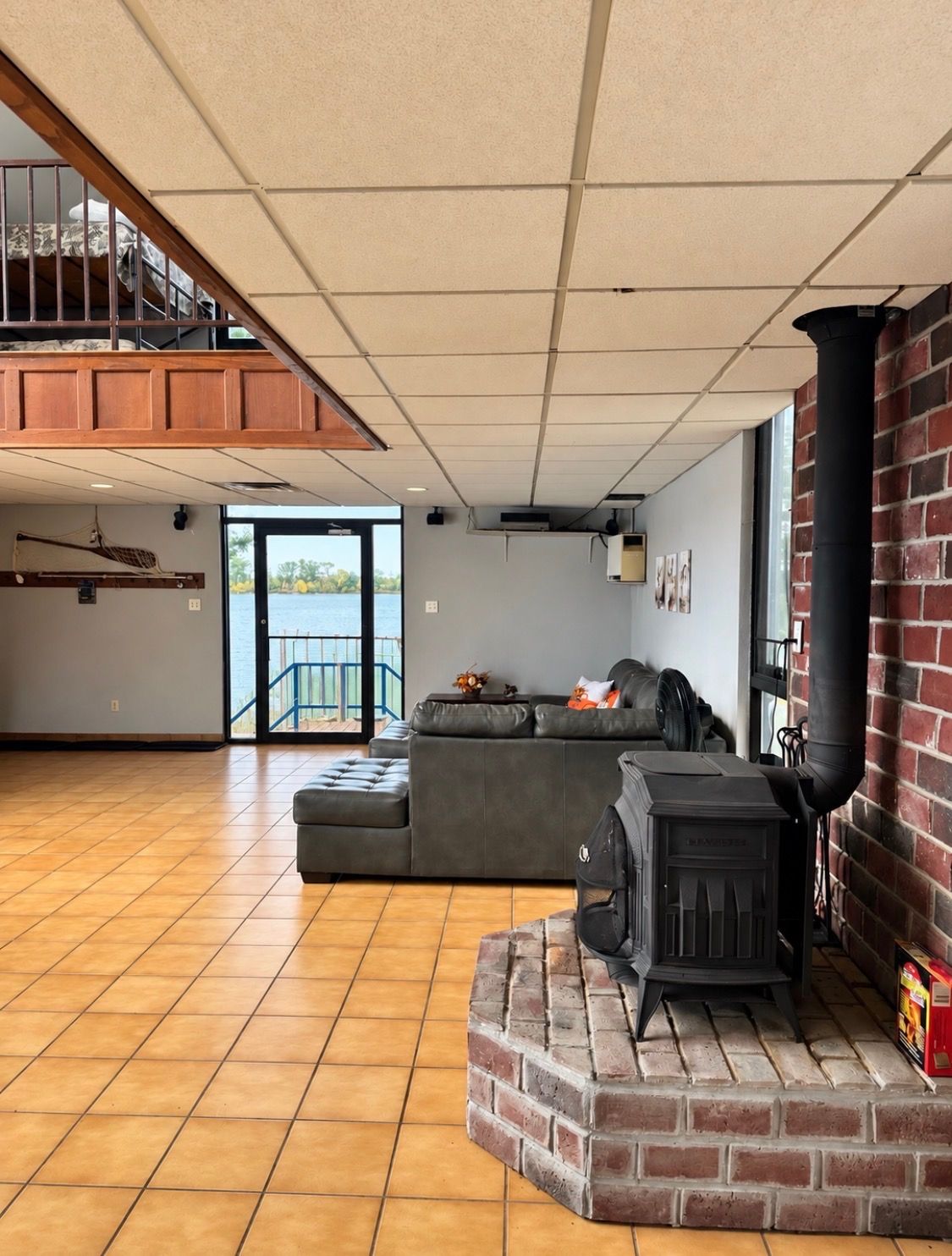 Een ruime woonkamer met een open haard, een balkon en uitzicht op de omgeving.