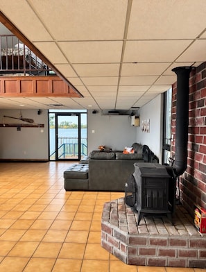 A spacious living area with a fireplace, a balcony, and a view of the outdoors.