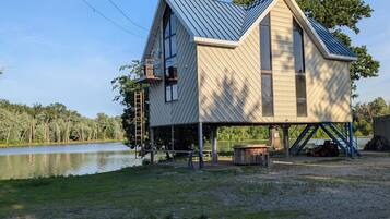 A house with a sloped roof, large windows, and a covered porch area.