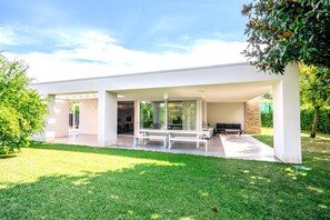 A modern house with a covered patio, a dining area, and a garden. - Villa 'Blanka' with Shared Pool, Wi-Fi and Air Conditioning (Bardolino)