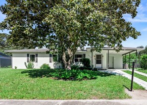 A single-story house with a front porch, a tree in front, and a clear sky. - Heated Pool Retreat Near Manatees & Springs (Citrus Springs)
