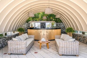 A curved ceiling bar area with wicker furniture and a stone wall backdrop. - Villa Arpino - Four Bedroom Villa, Sleeps 8 (Vico Equense)