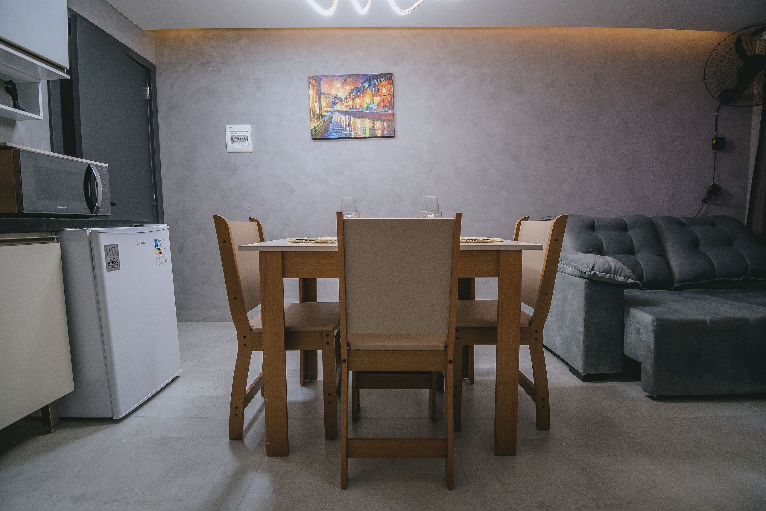 Un espacio habitable compacto con comedor, kitchenette y zona de estar.