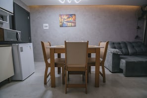 Un espacio habitable compacto con comedor, kitchenette y zona de estar.