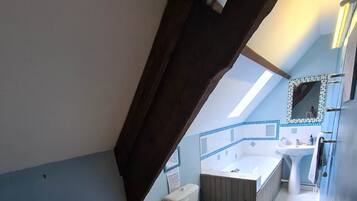 Une salle de bain avec une table en bois, des toilettes et un lavabo.