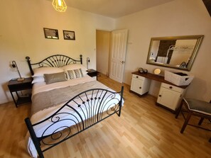 A bedroom with a bed, bedside tables, a dresser, a mirror, and a door. - Charming Large 4-bedroom house in Maupertuis perfect for families. Swimming Pool (Maupertuis)