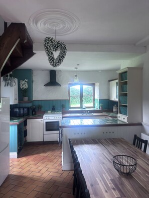 A kitchen with a heart-shaped decoration, a stove, a sink, and a dining table with chairs. - Charming Large 4-bedroom house in Maupertuis perfect for families. Swimming Pool (Maupertuis)