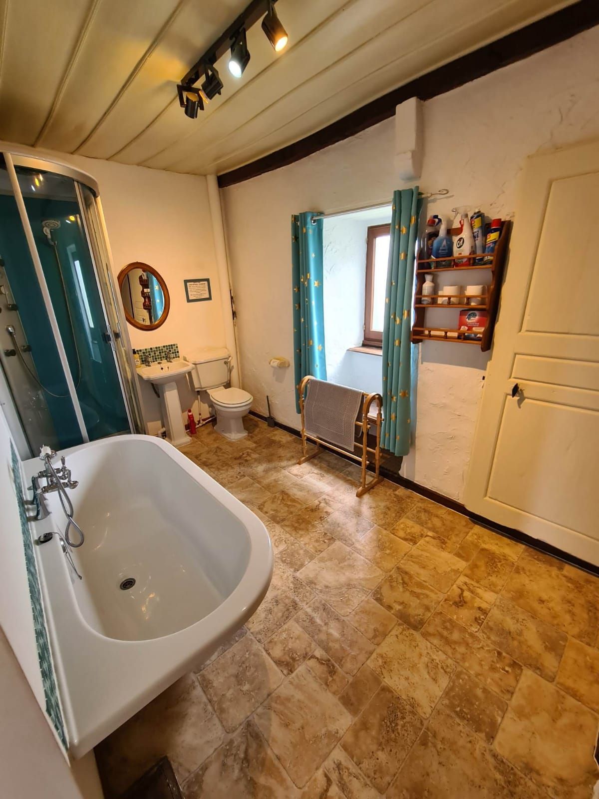 A bathroom with a bathtub, toilet, sink, and a shower enclosure.