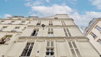 En byggnad med flera våningar i en klassisk arkitektonisk stil, med symmetriskt placerade fönster och fönsterluckor, och ett tydligt synligt gatunummer.
