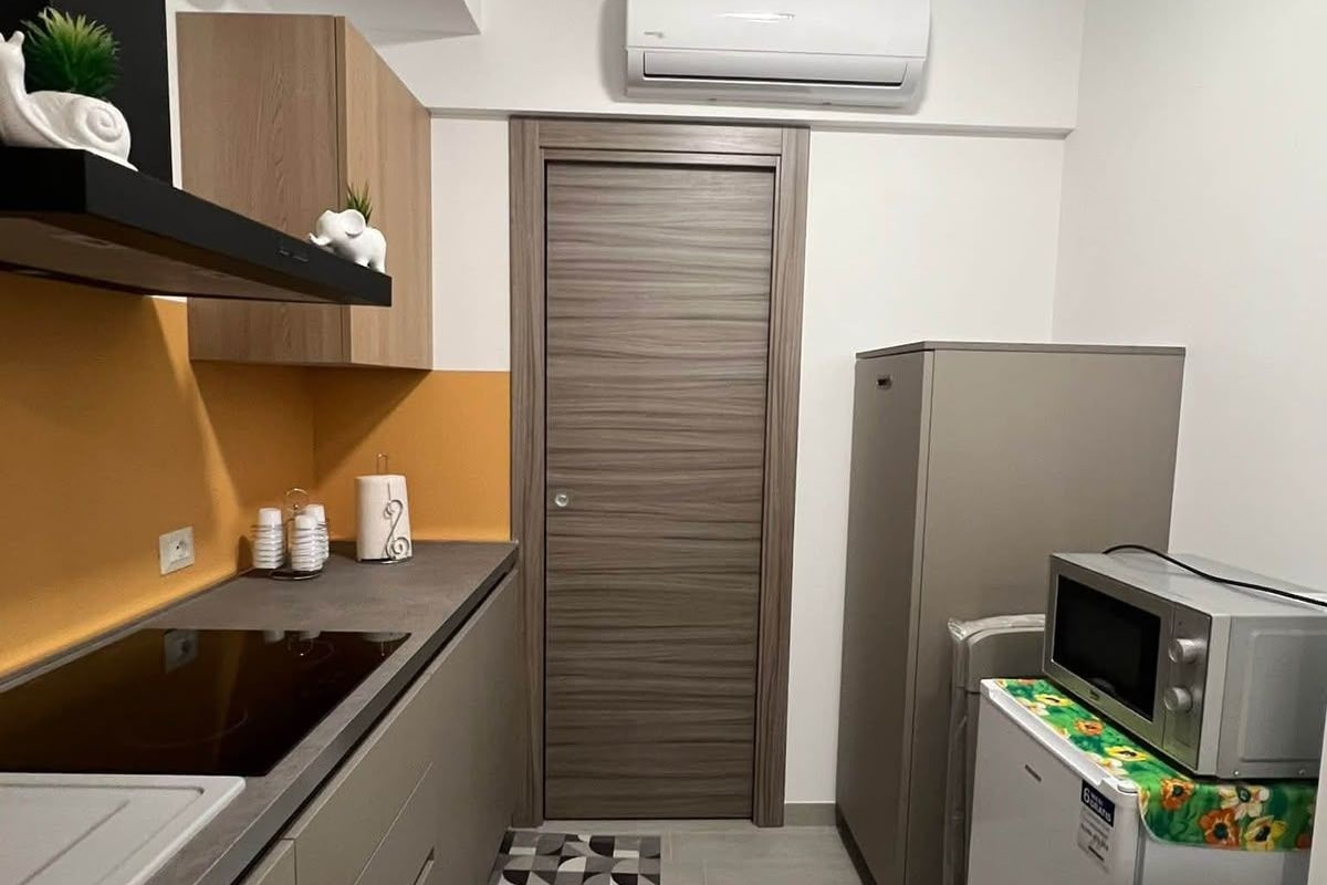 A compact kitchen with a microwave, a refrigerator, and a built-in oven.