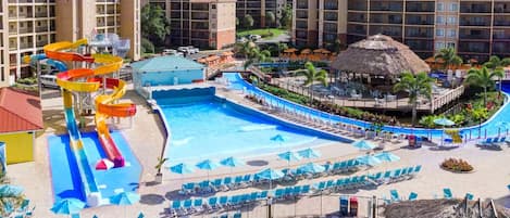 A hotel with a large pool, water slides, and sun loungers.