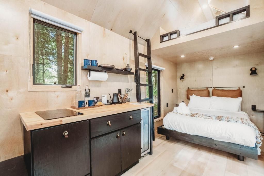 A compact bedroom with a bed, a bedside table, and a window.