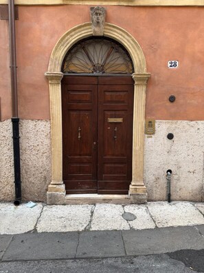 A double wooden door with a stone archway, a number plaque, and a small plaque below the door. - Apartment 'Casa Emi' with Balcony, Wi-Fi and Air Conditioning (Verona)