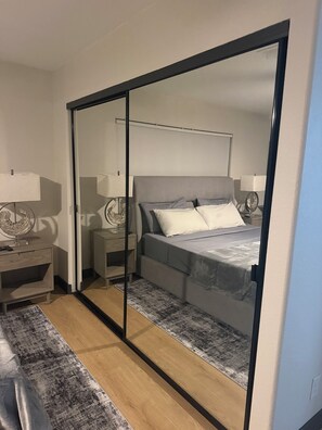 A bedroom with a bed, bedside tables, lamps, a rug, and a sliding door. - Villa Belle, a stylish retreat just 10 minutes from the Strip and the airport (Las Vegas)