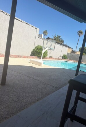 A pool area with a basketball hoop, palm trees, and a covered seating area. - Villa Belle, a stylish retreat just 10 minutes from the Strip and the airport (Las Vegas)