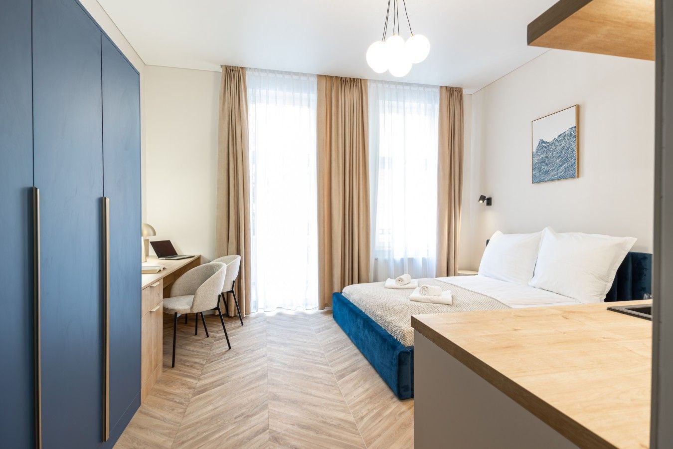A hotel room with a bed, a desk, and a chair.