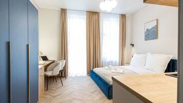 A hotel room with a bed, a desk, and a chair.