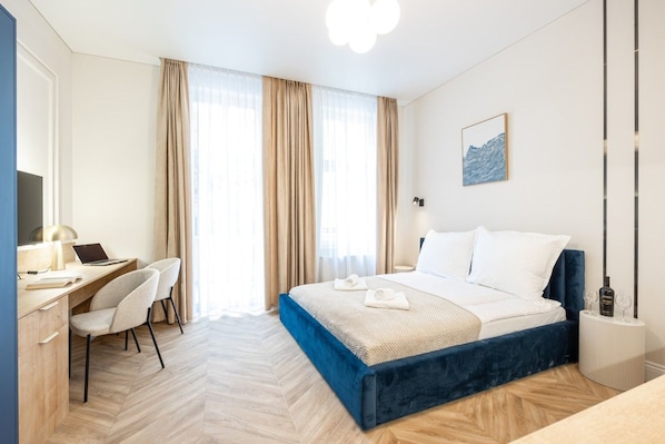 A hotel room with a bed, desk, chair, and a painting on the wall. - Armas 2 Stylowe Studio z Balkonem (Bydgoszcz)