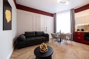 Uma sala de estar moderna com sofá, mesa de jantar e área de cozinha.
