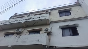 A multi-story building with several air conditioning units, including LG models, and a series of windows. - Ganesha Inn A River View Stay  (Rishikesh)