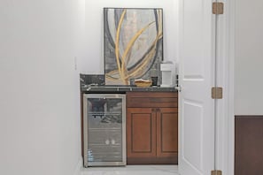 A compact kitchenette with a coffee maker, a refrigerator, and a cabinet. - Lake Las Vegas Home (Henderson)