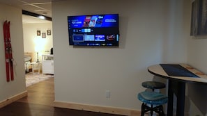 A hallway with a mounted television displaying various streaming services. - Quiet Property w/ Private Entrance (Weare)